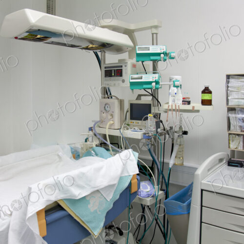 A baby cot with overhead lights in a hospital. A baby cot with overhead lights in a hospital.