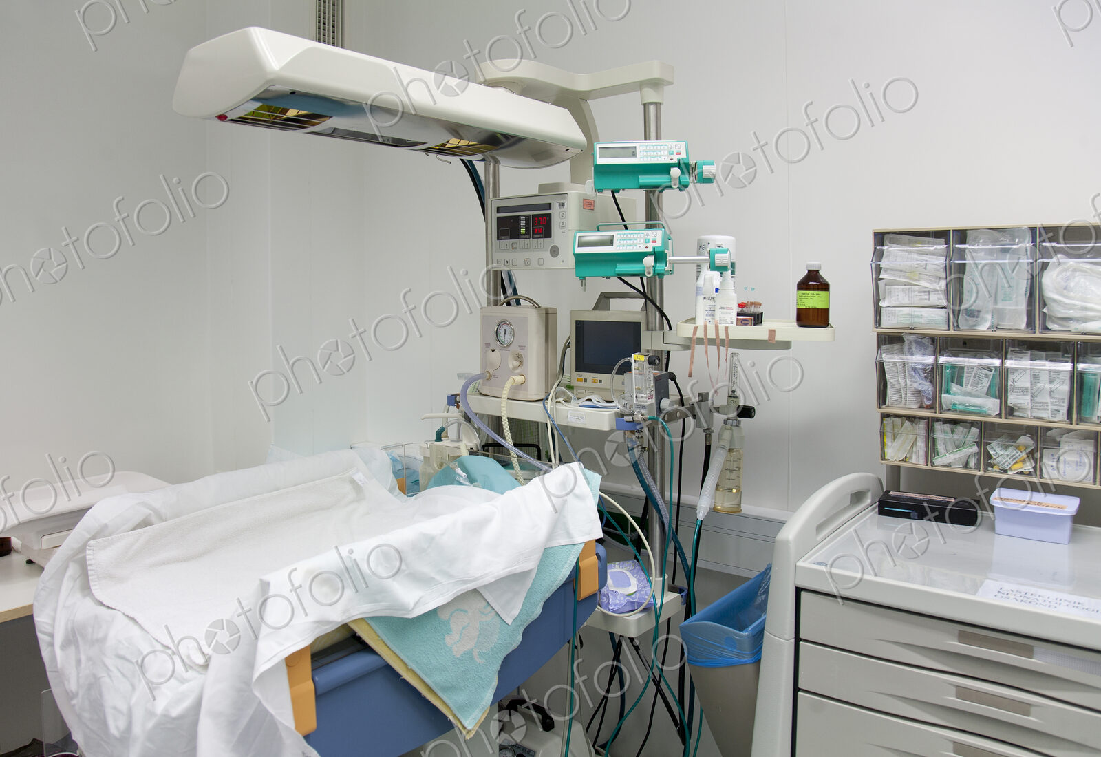 A baby cot with overhead lights in a hospital.