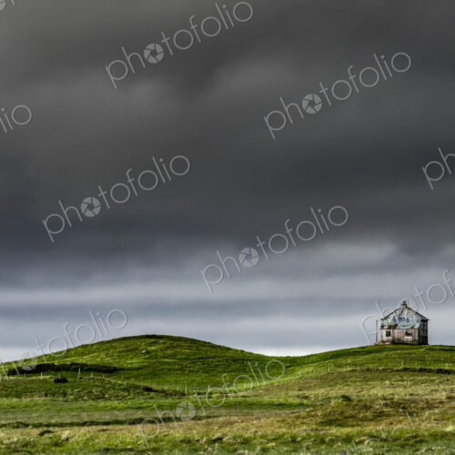A barn on the crest of a hill, and dark storm clouds glowering over the land. A barn on the crest of a hill, and dark storm clouds glowering over the land.