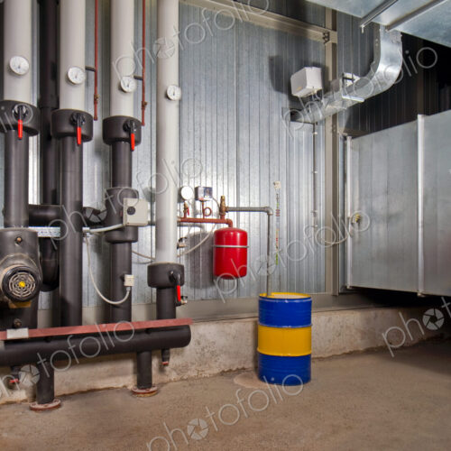 A basement,with zinc cladded steel,tubes,pipes,pressure gauges and barrels.,