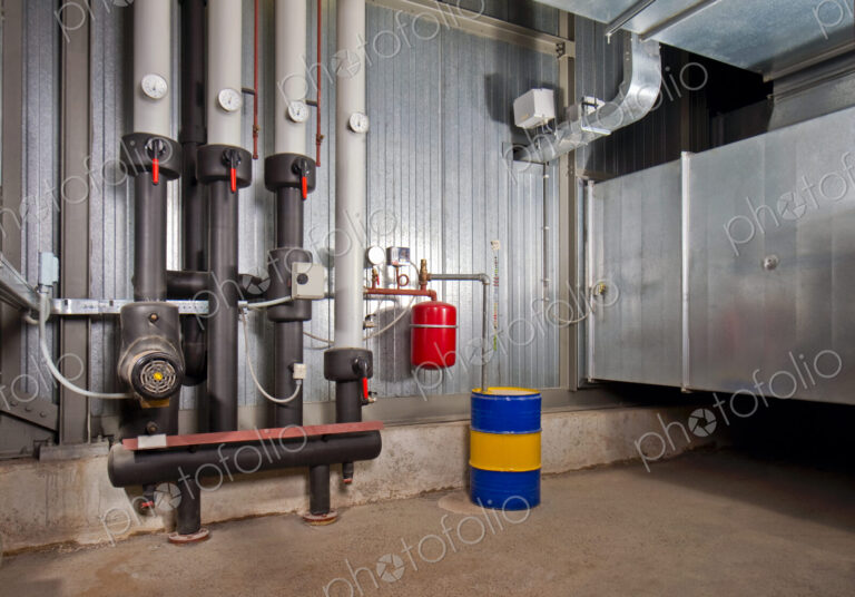 A basement,with zinc cladded steel,tubes,pipes,pressure gauges and barrels.,