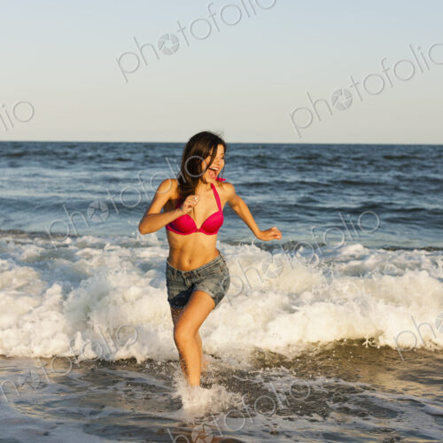 A beautiful young women at the water's edge on the beach in Atlantic City. A beautiful young women at the water's edge on the beach in Atlantic City.