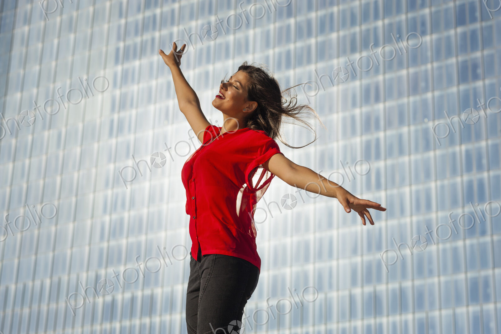 A beautiful young women on the boardwalk in Atlantic City, in front of a blue tiled wall.