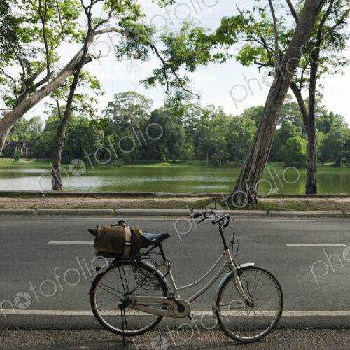 A bicycle with basket parked on the road to the Angkor Temples.