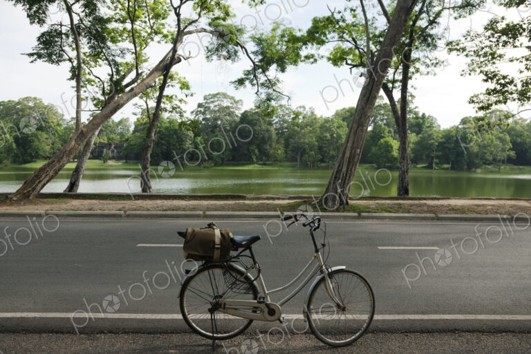 A bicycle with basket parked on the road to the Angkor Temples.