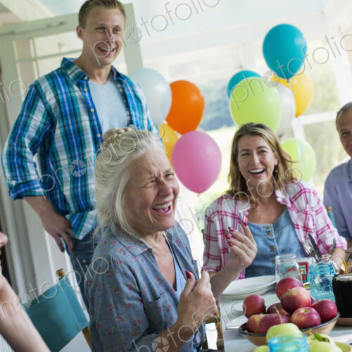 A birthday party in a farmhouse kitchen. A group of adults and children gathered…