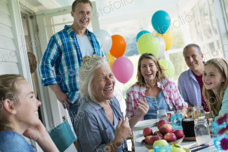 A birthday party in a farmhouse kitchen. A group of adults and children gathered…