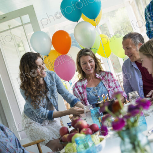 A birthday party in a farmhouse kitchen. A group of adults and children gathered…