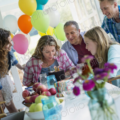 A birthday party in a farmhouse kitchen. A group of adults and children gathered…