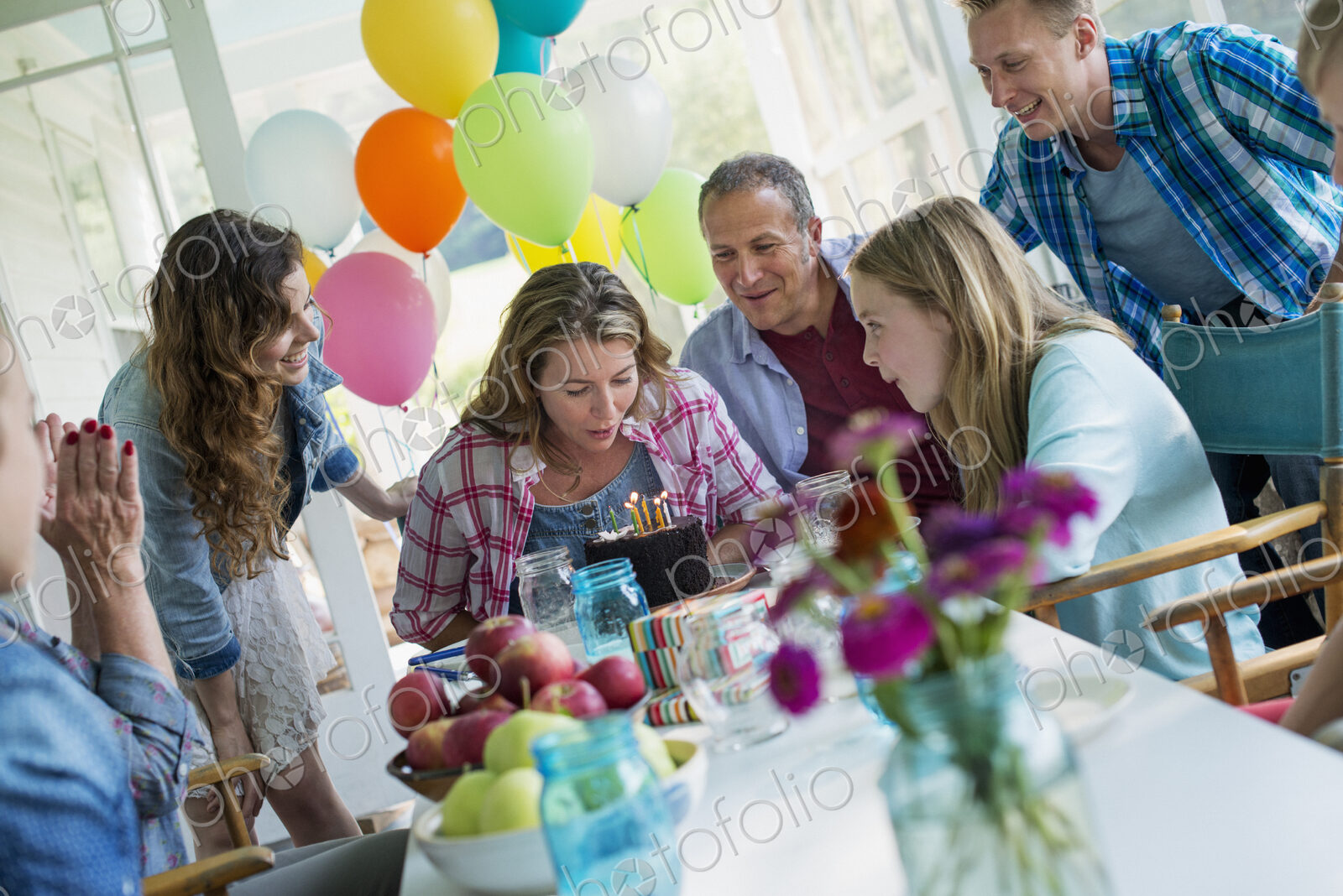 A birthday party in a farmhouse kitchen. A group of adults and children gathered…