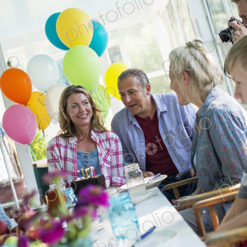 A birthday party in a farmhouse kitchen. A group of adults and children gathered…