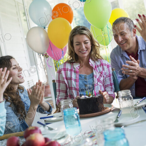 A birthday party in a farmhouse kitchen. A group of adults and children gathered… A birthday party in a farmhouse kitchen. A group of adults and children gathered…