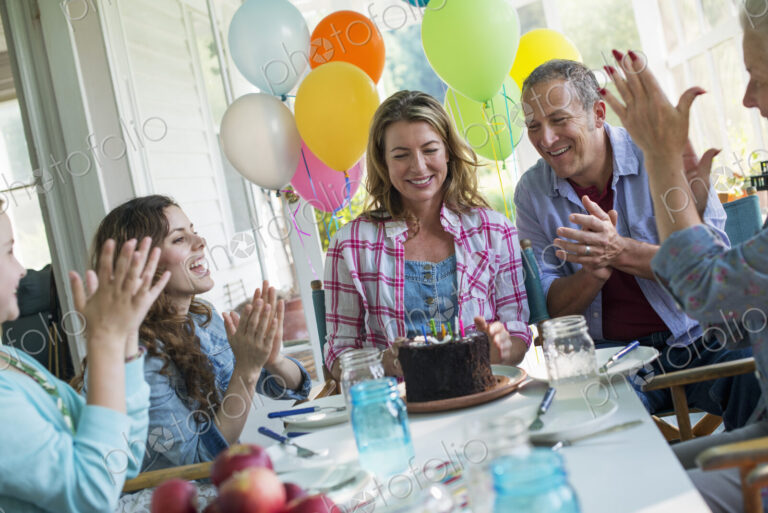 A birthday party in a farmhouse kitchen. A group of adults and children gathered…