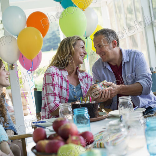 A birthday party in a farmhouse kitchen. A group of adults and children gathered…
