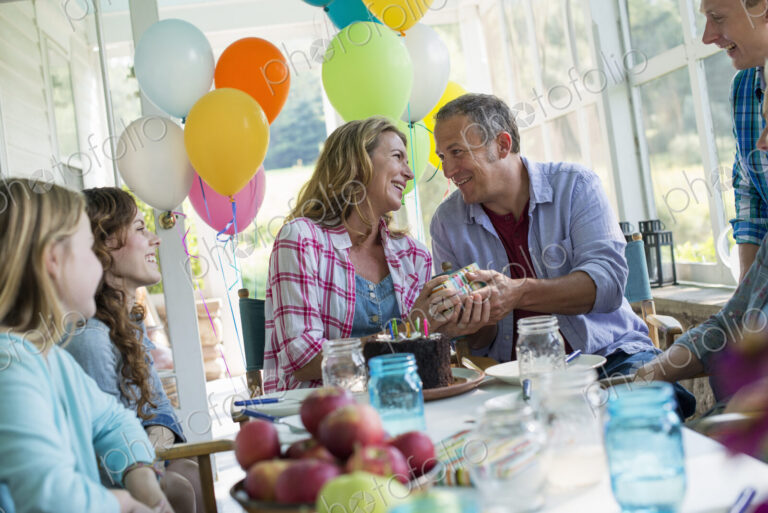 A birthday party in a farmhouse kitchen. A group of adults and children gathered…