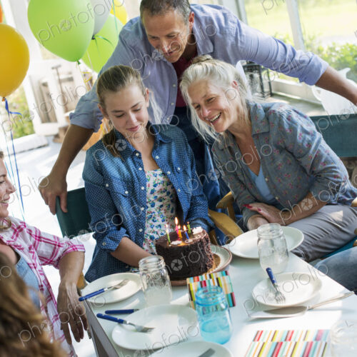 A birthday party in a farmhouse kitchen. A group of adults and children gathered… A birthday party in a farmhouse kitchen. A group of adults and children gathered…