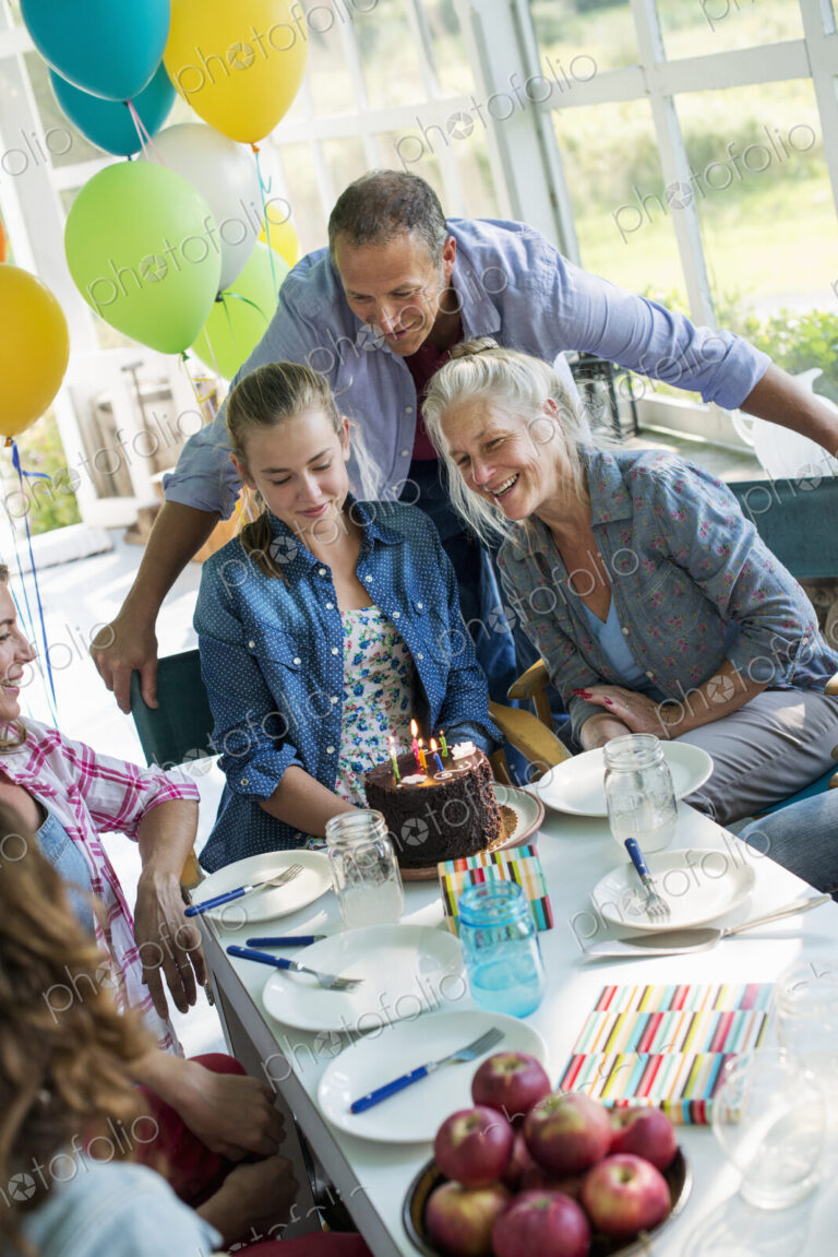 A birthday party in a farmhouse kitchen. A group of adults and children gathered…