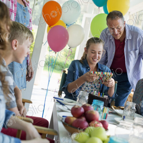 A birthday party in a farmhouse kitchen. A group of adults and children gathered… A birthday party in a farmhouse kitchen. A group of adults and children gathered…