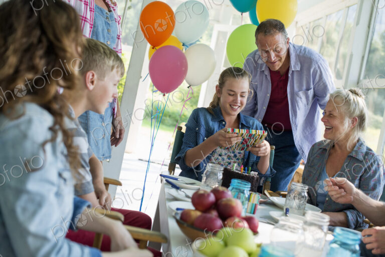 A birthday party in a farmhouse kitchen. A group of adults and children gathered…