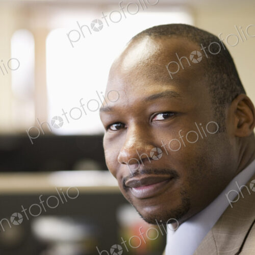 A black businessman at his desk in his office. A black businessman at his desk in his office.