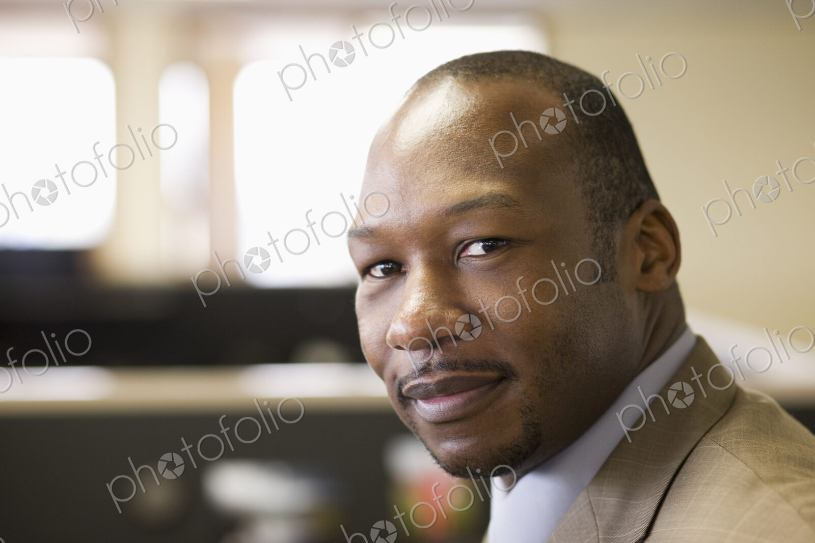 A black businessman at his desk in his office.