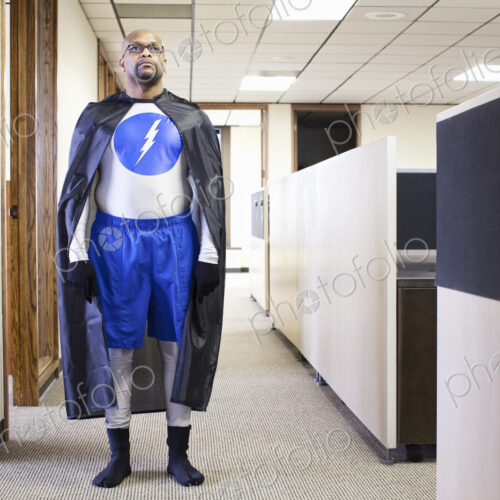 A black businessman office super hero standing in an office hallway. A black businessman office super hero standing in an office hallway.