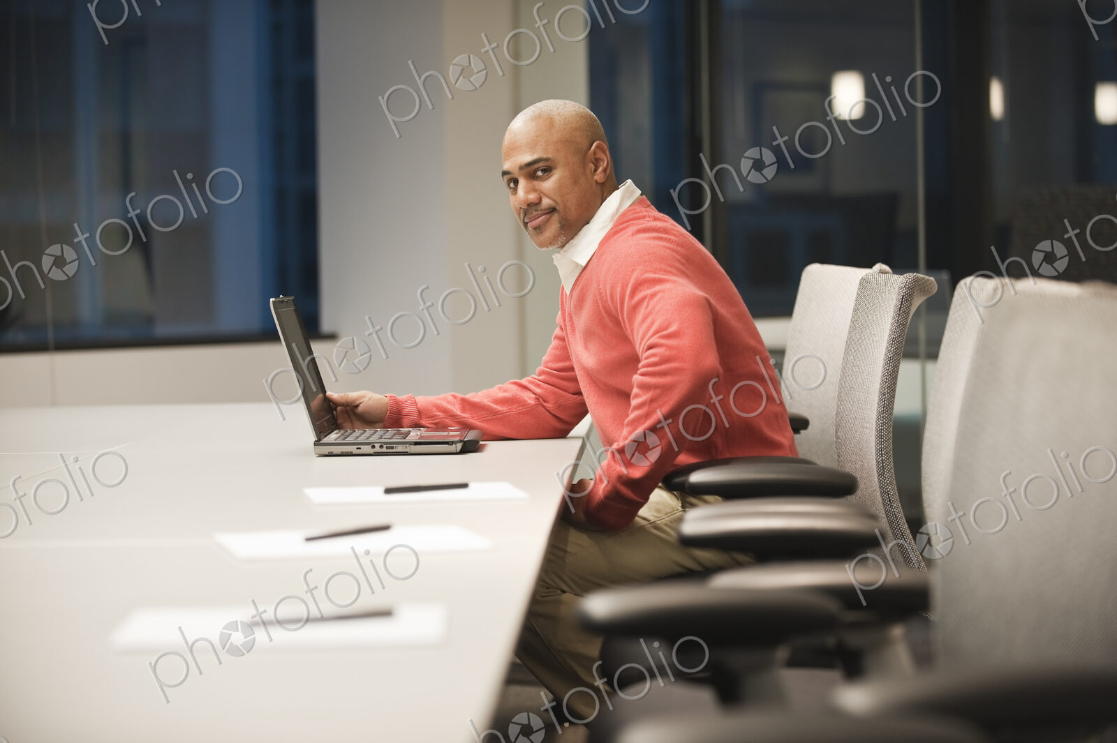 A black businessman working at a conference table at night.