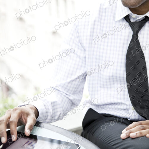 A black businessman working on a notebook computer.. A black businessman working on a notebook computer..