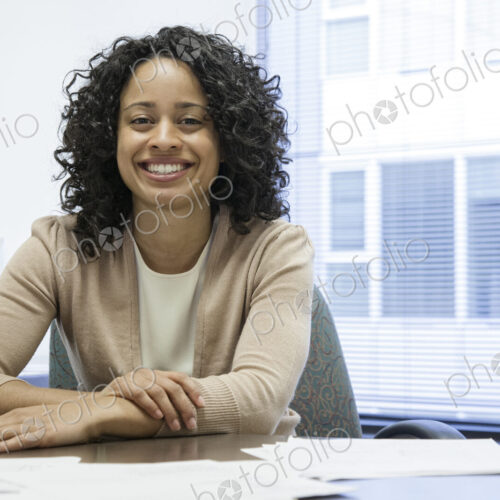 A black businesswoman at her desk in her office. A black businesswoman at her desk in her office.