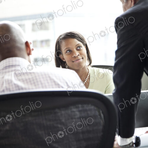 A black businesswoman listening during a meeting in a convention center meeting room. A black businesswoman listening during a meeting in a convention center meeting room.