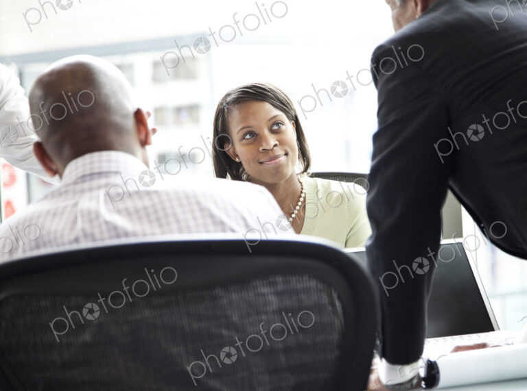 A black businesswoman listening during a meeting in a convention center meeting room.