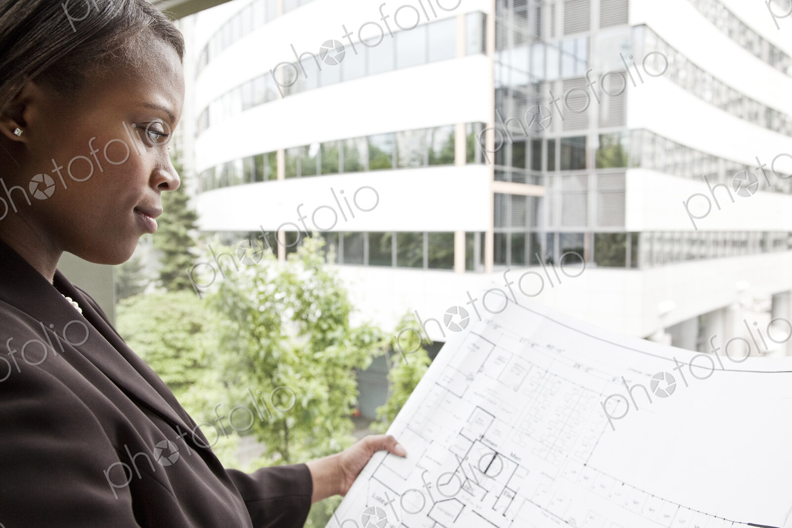 A black businesswoman looking at plans for a new office