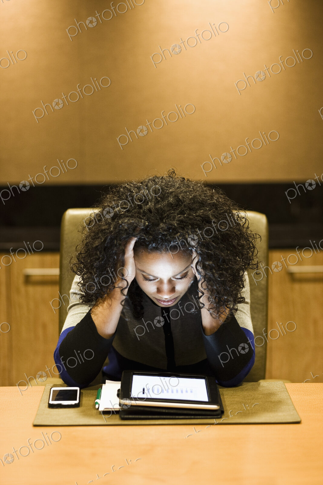 A black businesswoman looking intently at the screen of a notebook computer.