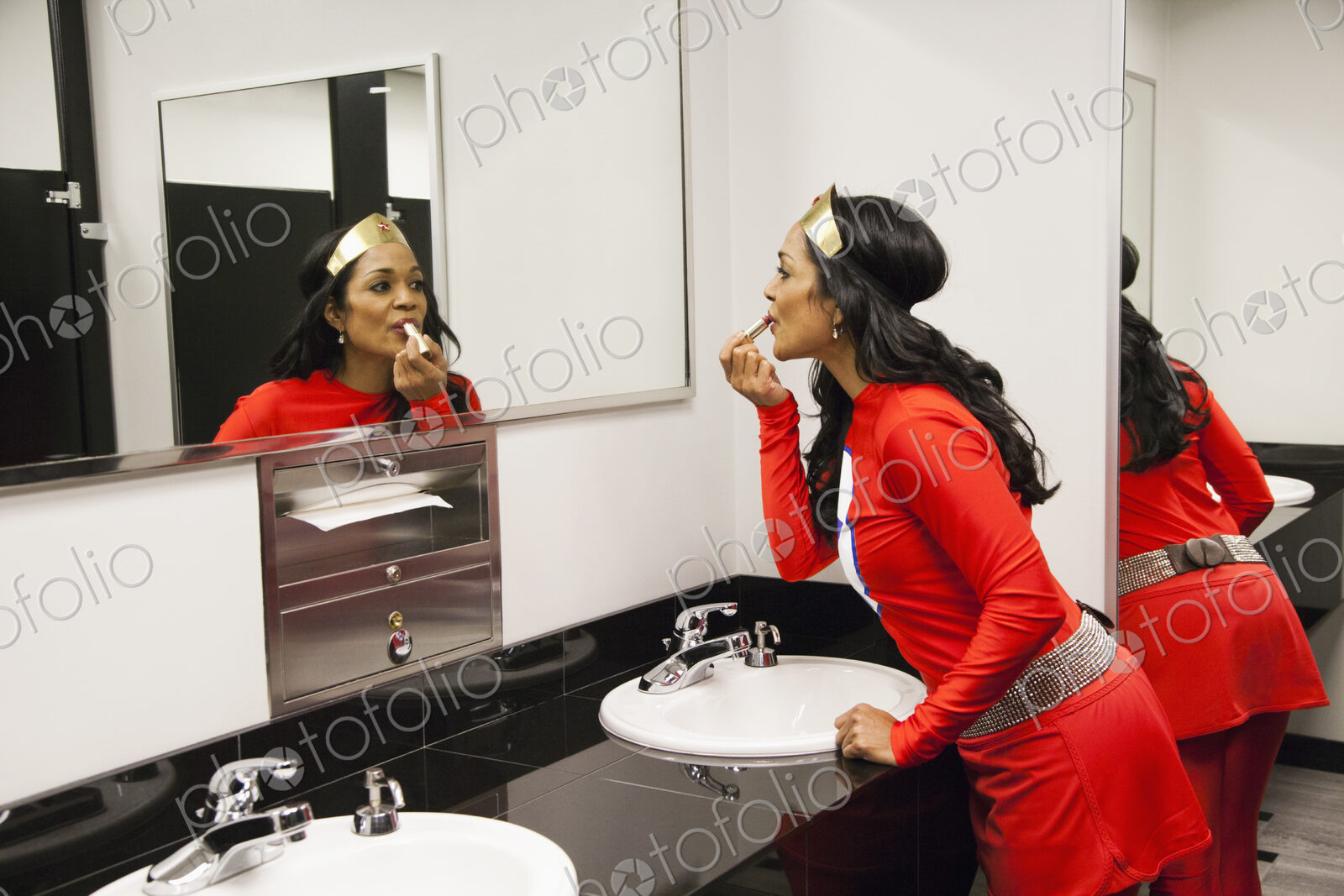 A black businesswoman office super hero takes a make up break between super hero feats.