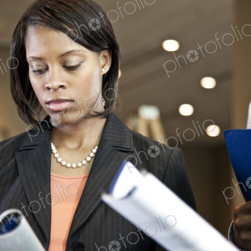 A black businesswoman reading a report. A black businesswoman reading a report.