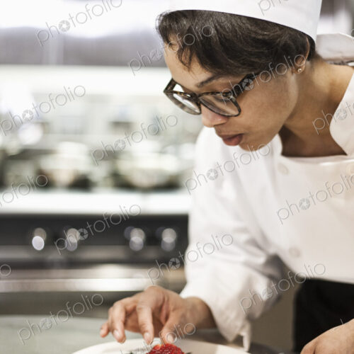 A black female chef working in a commercial kitchen,