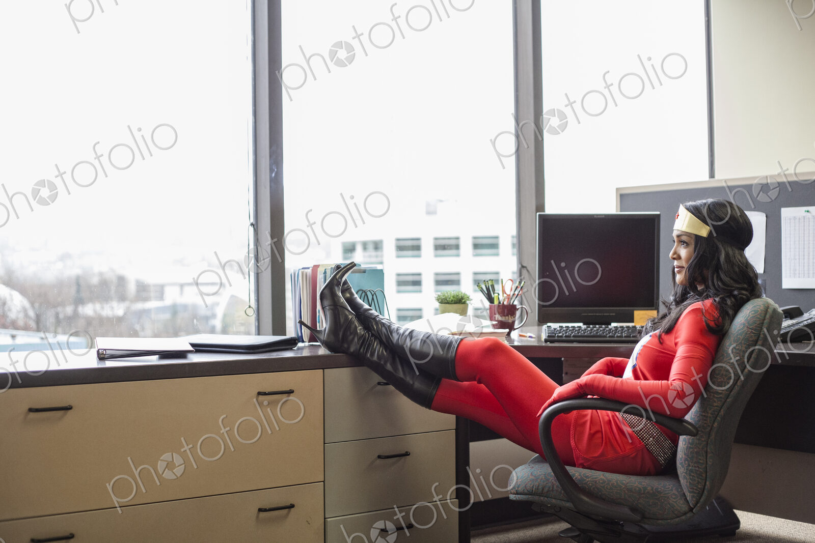 A black office superhero business woman sits in her office and ponders her next…