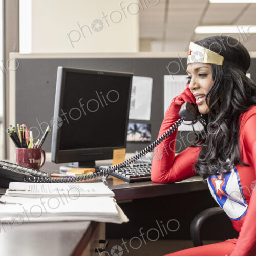 A black office superhero businesswoman takes a call in her office from a client. A black office superhero businesswoman takes a call in her office from a client.