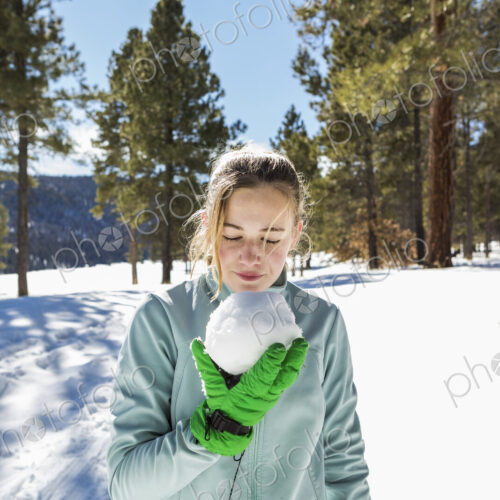 A blonde teenage girl holding a snowball