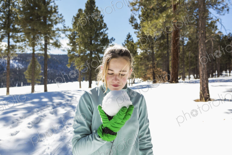 A blonde teenage girl holding a snowball