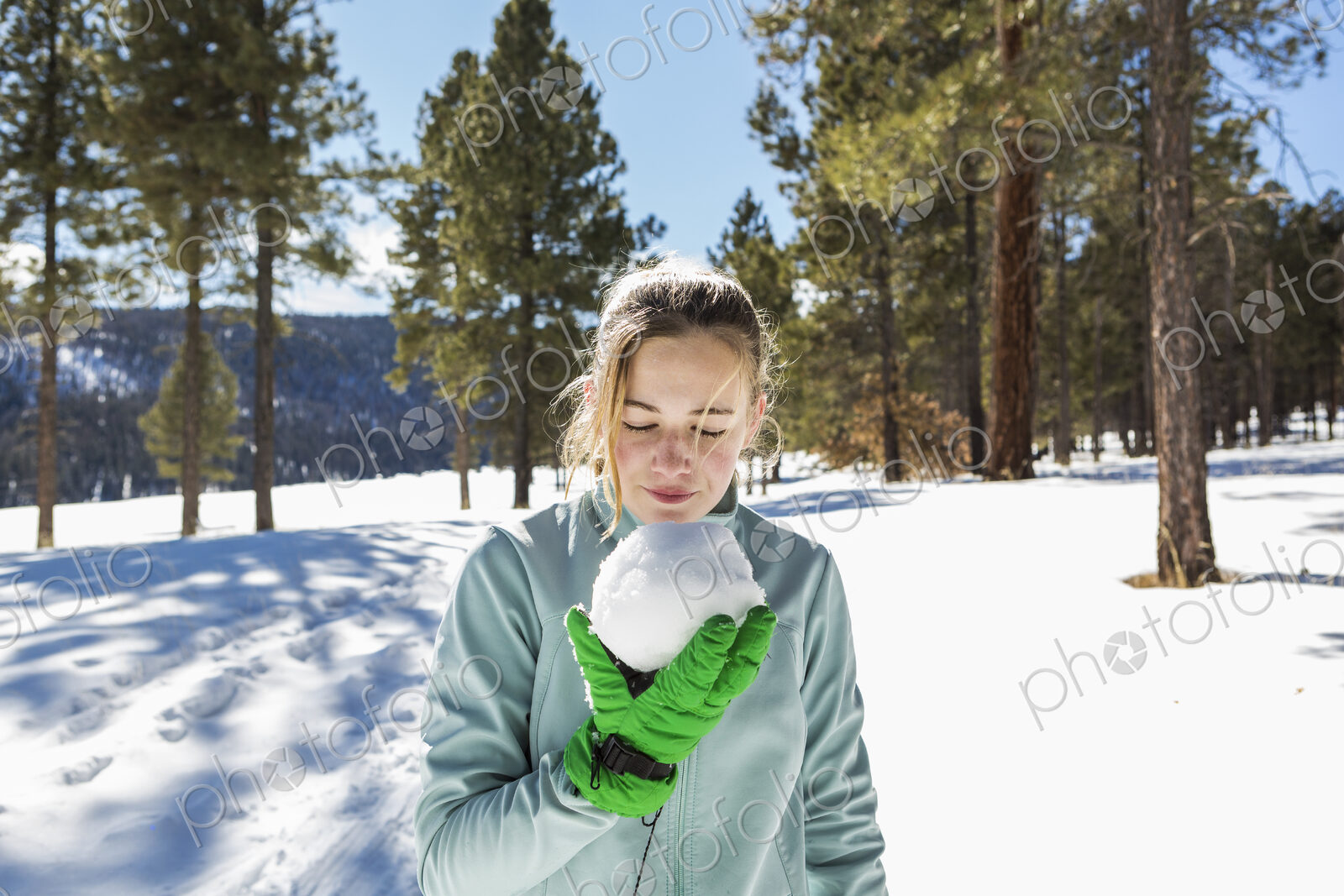 A blonde teenage girl holding a snowball