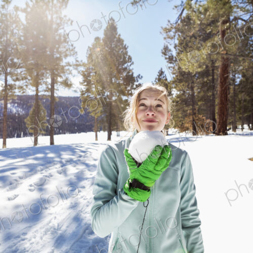 A blonde teenage girl holding a snowball