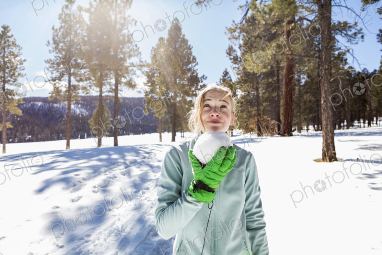 A blonde teenage girl holding a snowball