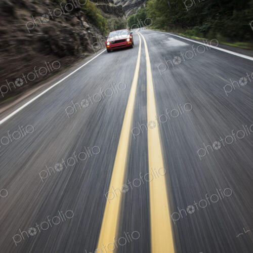 A blurred road and a car traveling along a highway in eastern Washington State, USA. A blurred road and a car traveling along a highway in eastern Washington State, USA.
