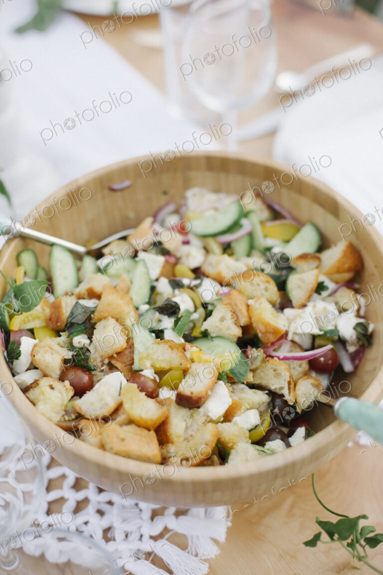 A bowl of mixed salad on a table in a garden.
