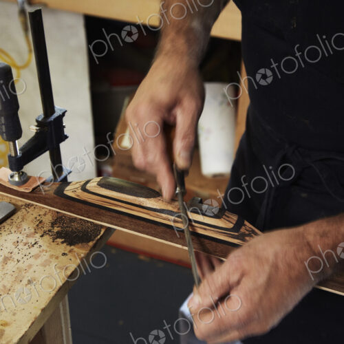 A bowman, a skilled man making a bow, in his workshop.