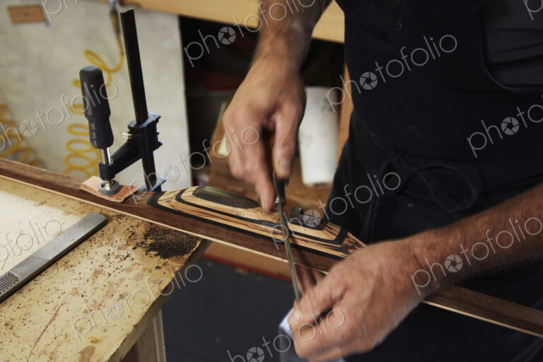 A bowman, a skilled man making a bow, in his workshop.