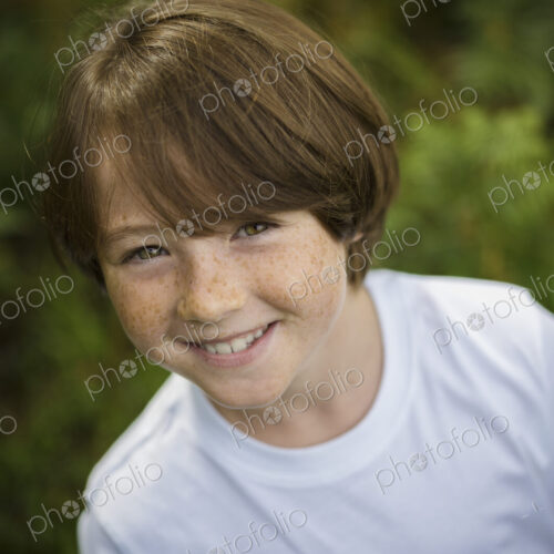 A boy in a white tee-shirt looking up at the camera. A boy in a white tee-shirt looking up at the camera.