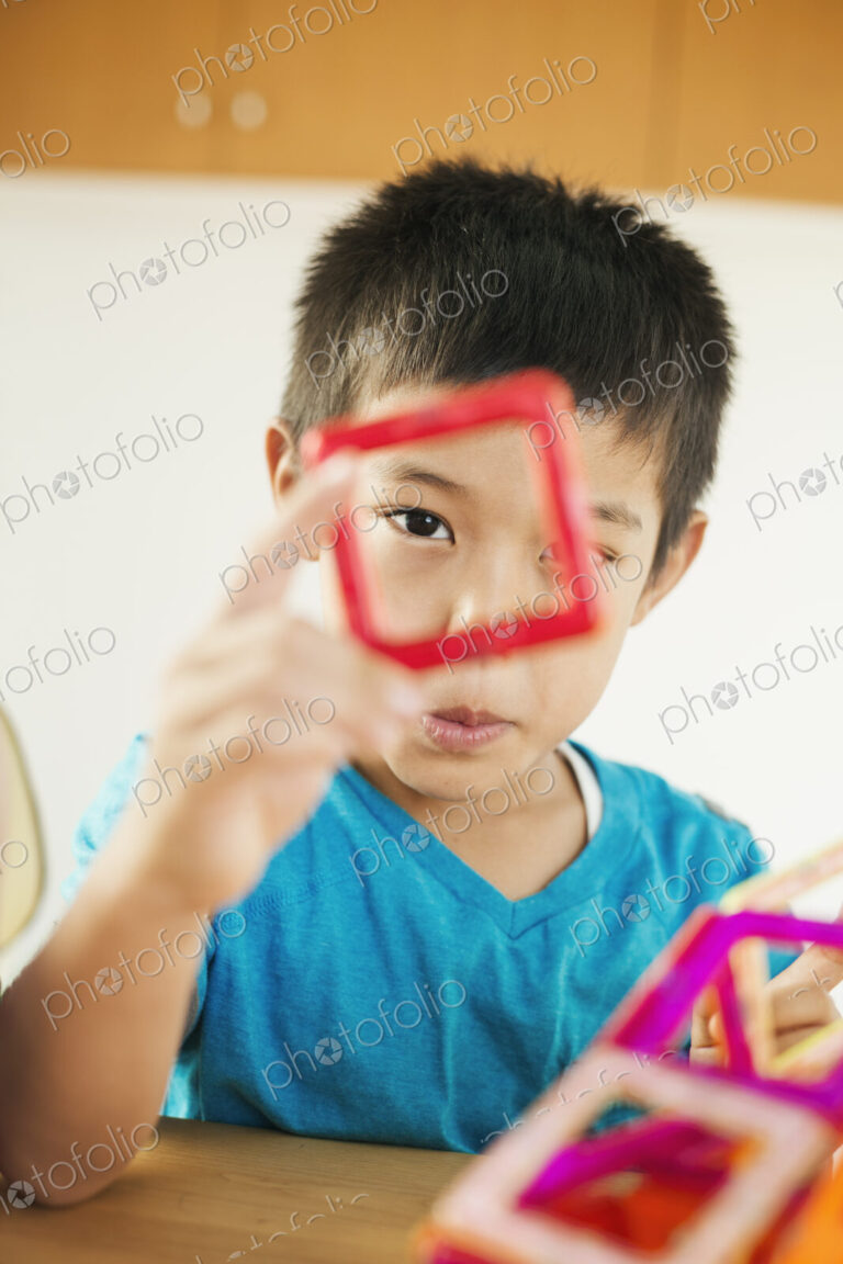 A boy playing with coloured geometric shapes.