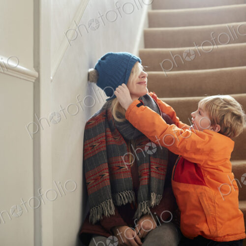 A boy pulling a hat over his mother's eyes. A boy pulling a hat over his mother's eyes.